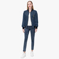 Full-length model wearing the SANCTUS NOVA Royal Navy signature bomber jacket with black ribbed trim and tonal cross-SN repeat.